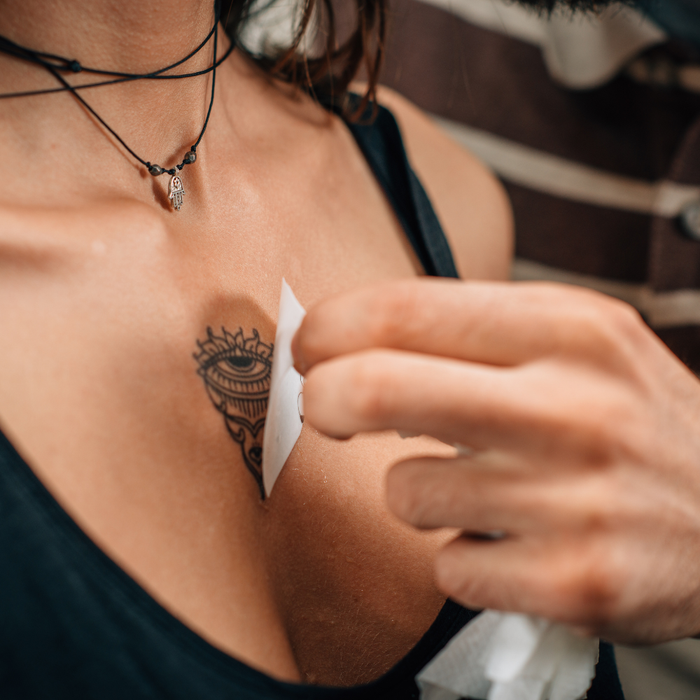 Person applying a temporary tattoo to a persons chest.